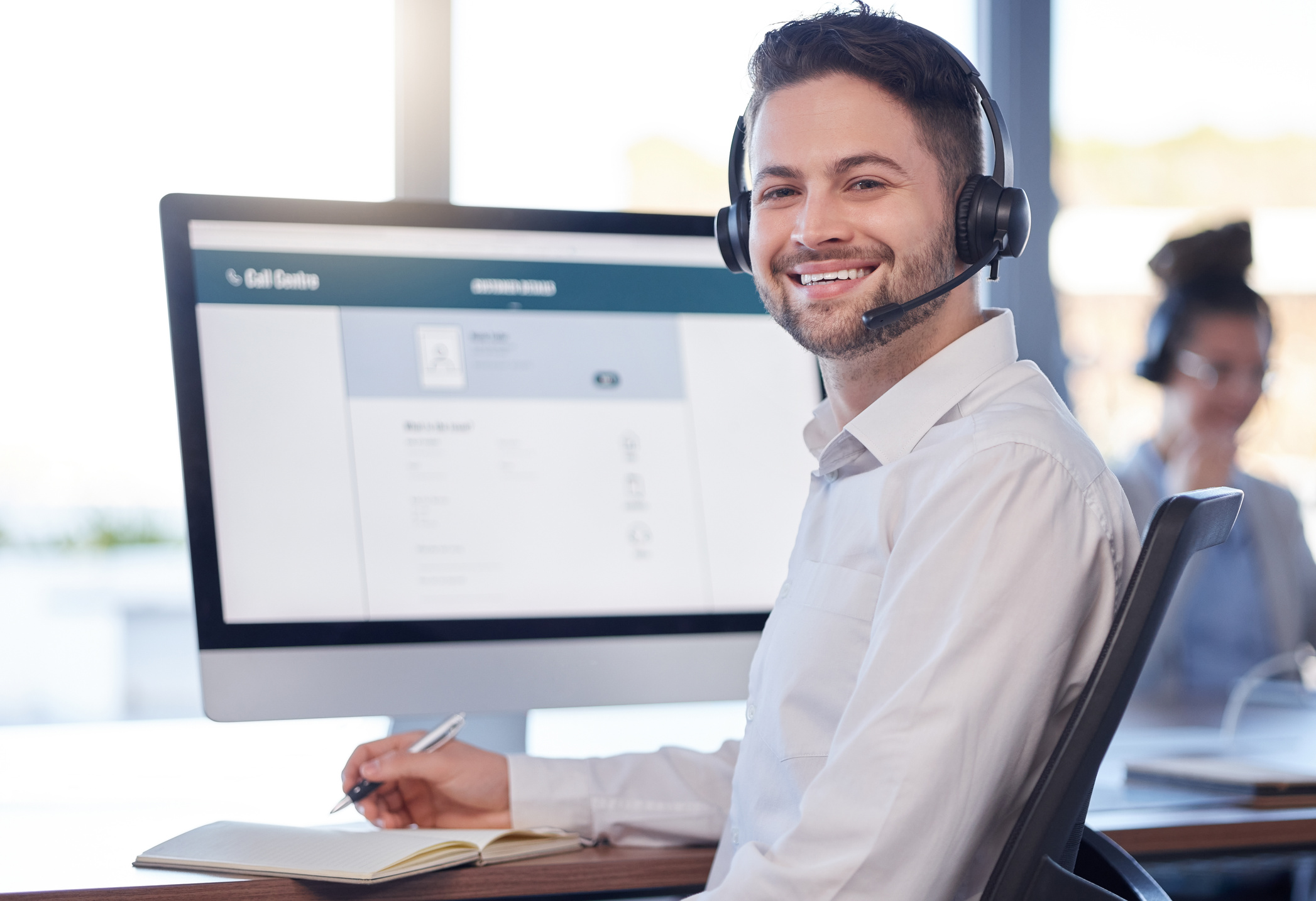 Man at call center, contact us and customer service job, employee smile and CRM, consultant in workplace. Professional, portrait and communication, male with headset with help desk and telemarketing